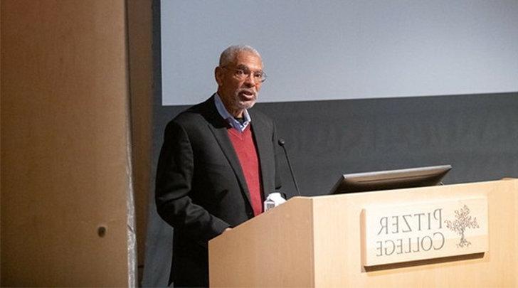 梅尔文L. 奥利弗 stands at the podium in Pitzer's Benson auditorium.